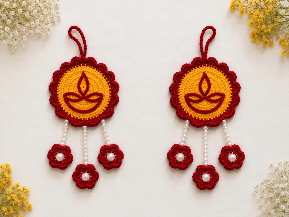Pair of handmade crochet diya wall hangings in red and yellow with pearl drops, by Crochet Craft