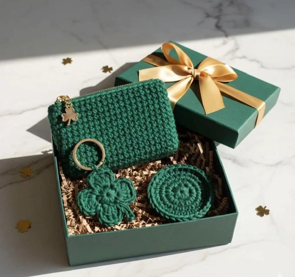 Handmade green crochet gift box set — zip pouch, four-leaf clover keychain and round coaster in a green box with a gold ribbon