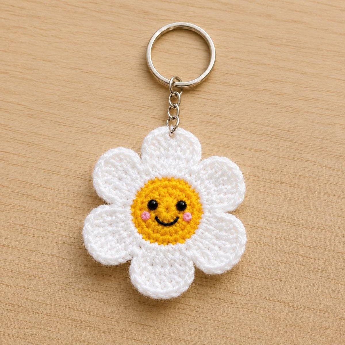 Handmade crochet white daisy keychain with a smiley face and rosy cheeks
