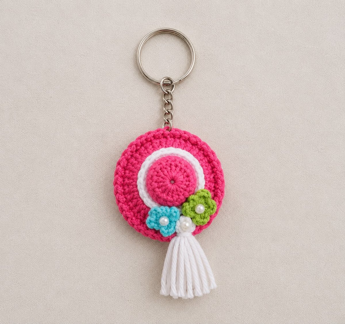 Handmade crochet pink sun-hat keychain with tiny flowers, pearls and white tassel