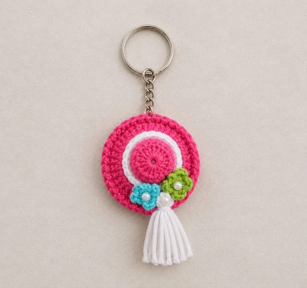 Handmade crochet pink sun-hat keychain with tiny flowers, pearls and white tassel
