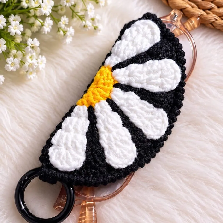 Handmade black crochet specs holder with a white and yellow daisy, on a clip